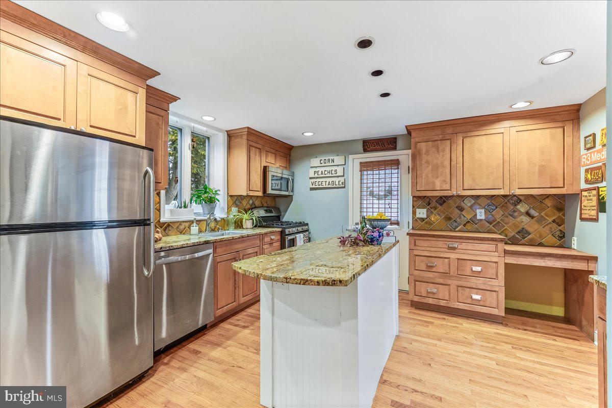 42 Preston Road Media, PA 19063 - Photo 11 of 35 a kitchen with stainless steel appliances granite countertop a refrigerator a sink dishwasher a stove and white countertops with wooden floor