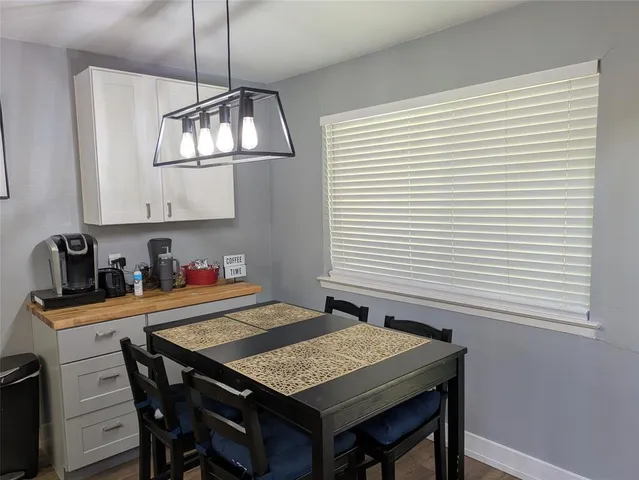 a kitchen with a table chairs and cabinets