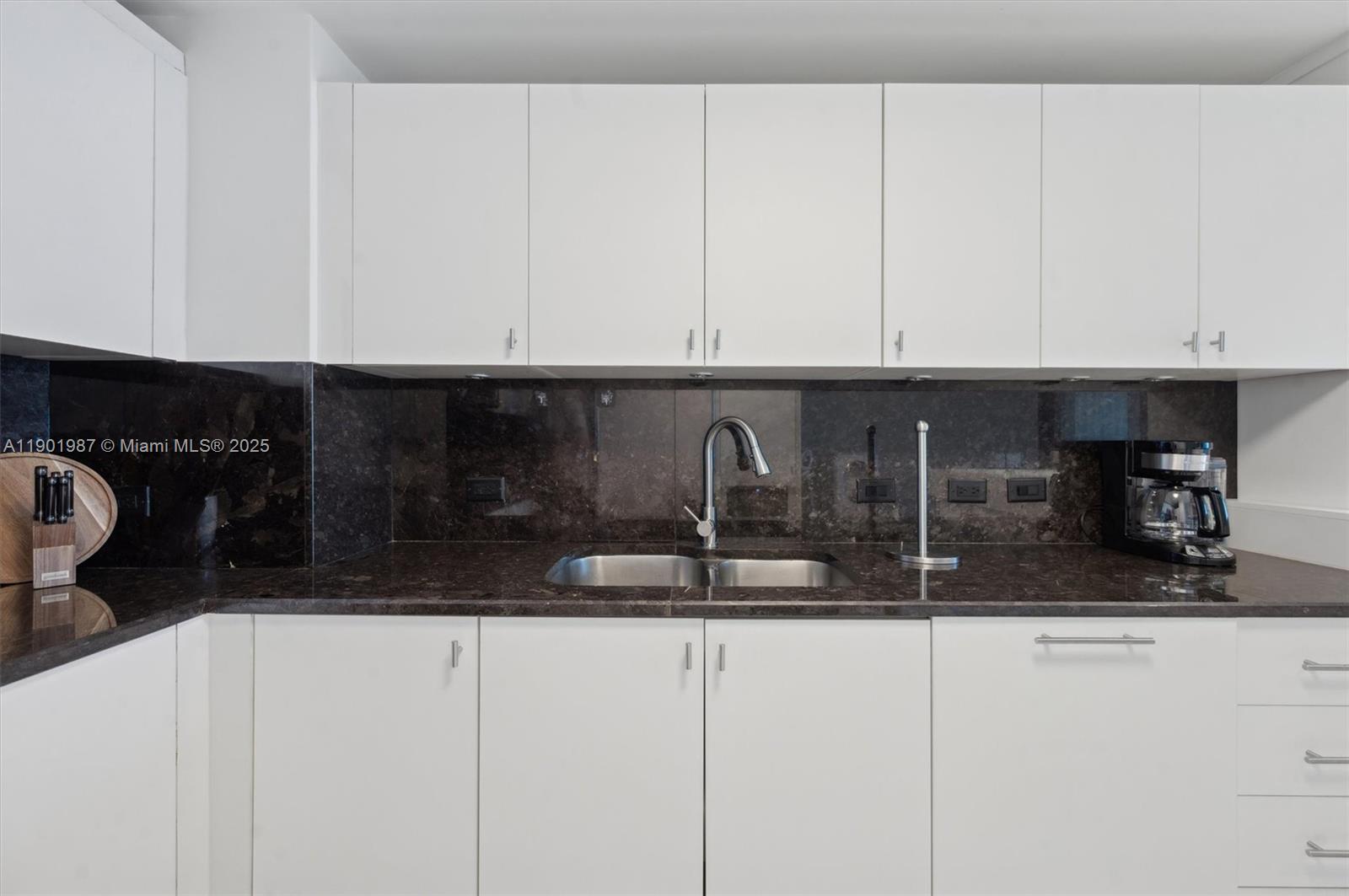 6899 Collins Avenue, Unit 702 Miami Beach, FL 33141 - Photo 12 of 47 a kitchen with a sink and cabinets