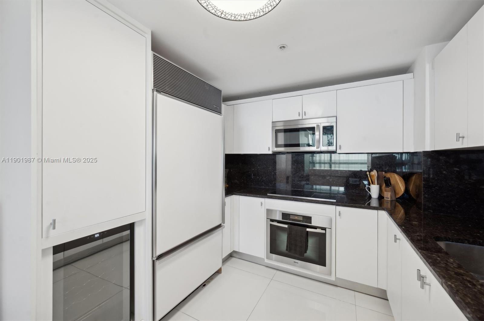 6899 Collins Avenue, Unit 702 Miami Beach, FL 33141 - Photo 13 of 47 a kitchen with a stove microwave and sink