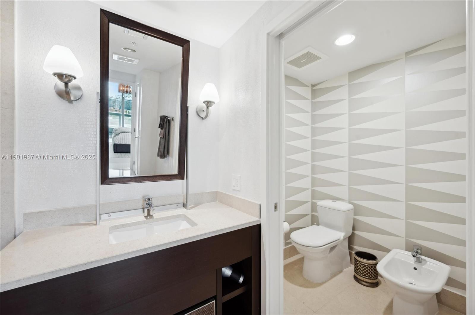 6899 Collins Avenue, Unit 702 Miami Beach, FL 33141 - Photo 18 of 47 a bathroom with a toilet sink and mirror