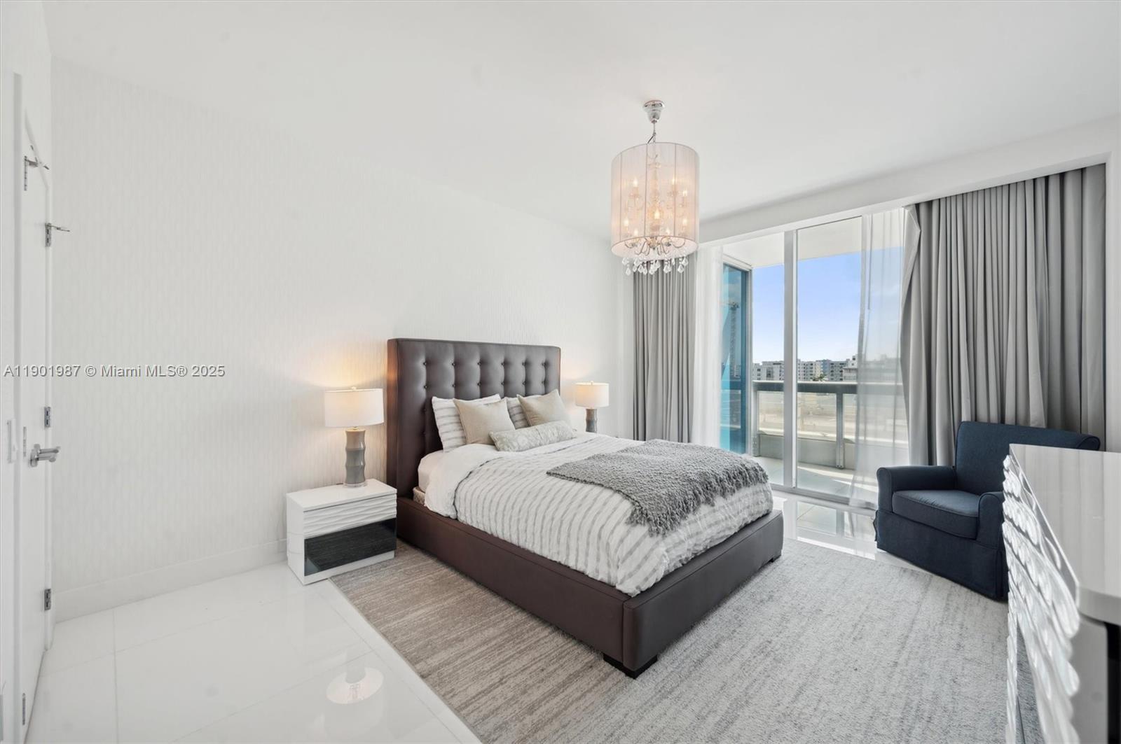 6899 Collins Avenue, Unit 702 Miami Beach, FL 33141 - Photo 21 of 47 a bedroom with a large bed and a chandelier