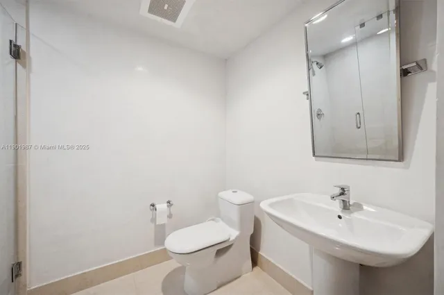 a bathroom with a toilet a sink and shower
