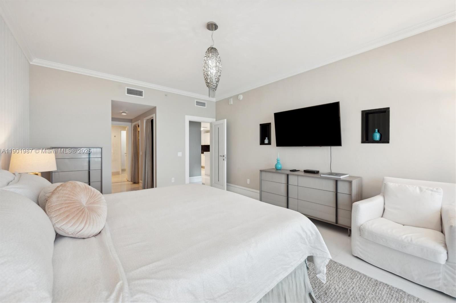 6899 Collins Avenue, Unit 702 Miami Beach, FL 33141 - Photo 37 of 47 a bedroom with a bed and a flat screen tv