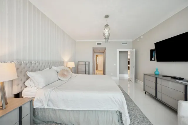 a bedroom with bed and flat tv with wooden floor