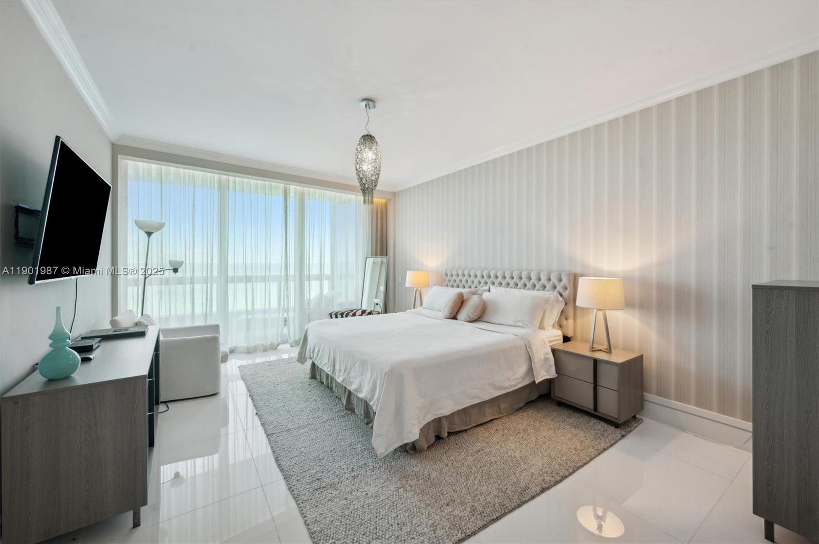 6899 Collins Avenue, Unit 702 Miami Beach, FL 33141 - Photo 39 of 47 a bedroom with bed and flat tv with wooden floor