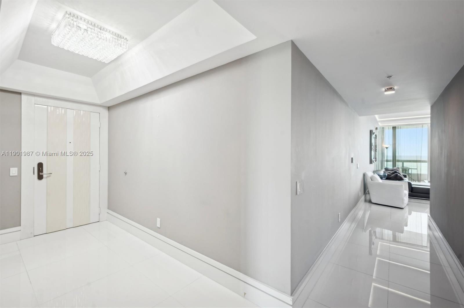 6899 Collins Avenue, Unit 702 Miami Beach, FL 33141 - Photo 4 of 47 a view of a hallway with a couch and chandelier
