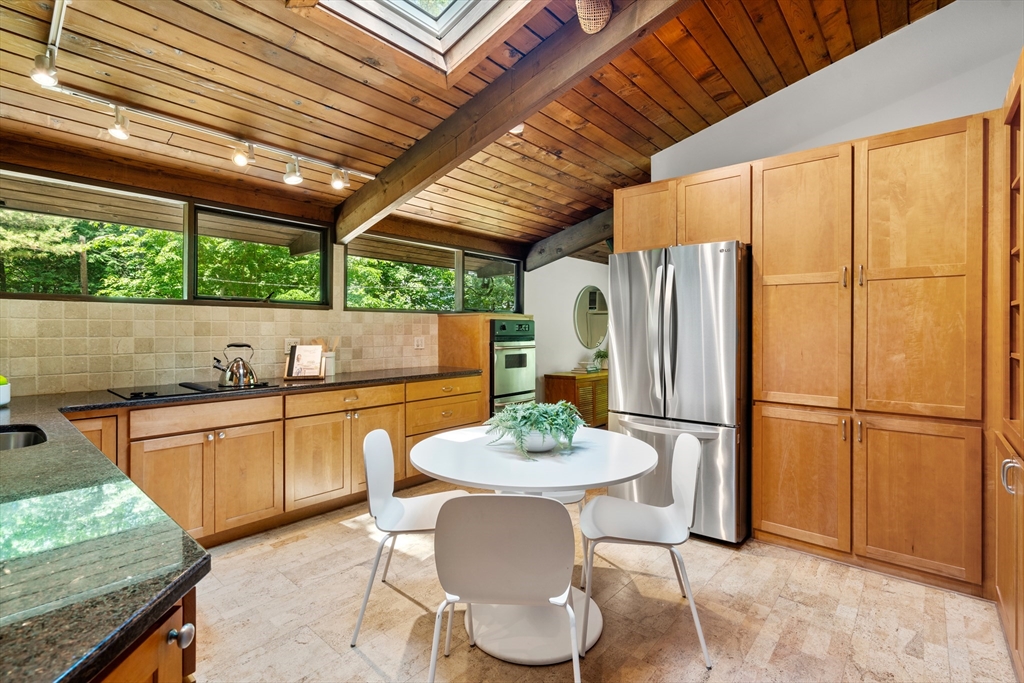 35 Sedgemeadow Road Wayland, MA 01778 - Photo 11 of 29 a kitchen with stainless steel appliances granite countertop a refrigerator a sink dishwasher with a dining table and chairs with wooden floor