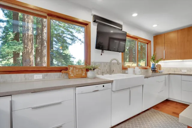 a dining room with wooden floor a chandelier a glass table and chairs