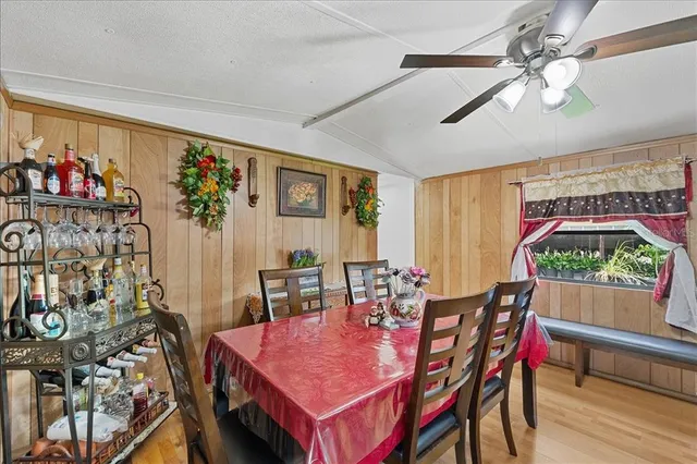 a dining room with furniture potted plants and wooden floor