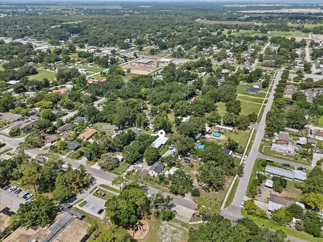 an aerial view of residential houses with outdoor space and trees