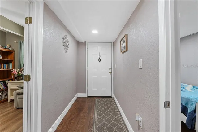 a view of a hallway with wooden floor and closet
