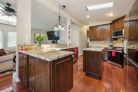 a kitchen with granite countertop a sink appliances and cabinets