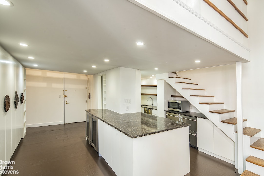 120 East 87th Street, Unit R18H Manhattan, NY 10128 - Photo 4 of 13 a kitchen with stainless steel appliances granite countertop a sink and a refrigerator