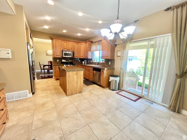 369 Culross Circle Tooele, UT 84074 - Photo 9 of 54 Kitchen featuring wood cabinetry, stainless steel appliances, and a central island with a stone countertop