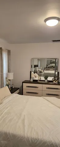 a view of bedroom with furniture and lamp