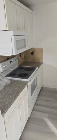 a view white cabinets and a wooden floor