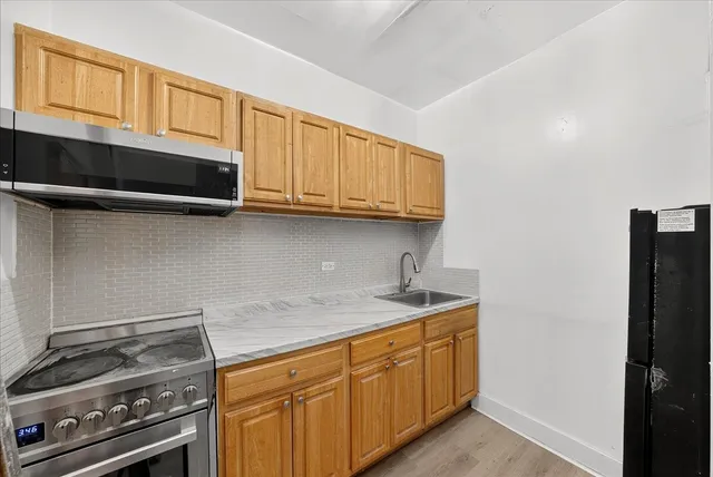 a kitchen with stainless steel appliances granite countertop a stove a sink and a microwave