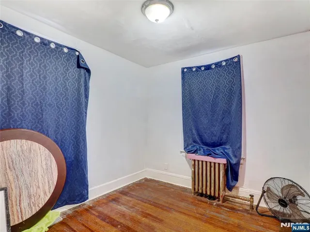 a view of a bedroom with wooden floor and a sink