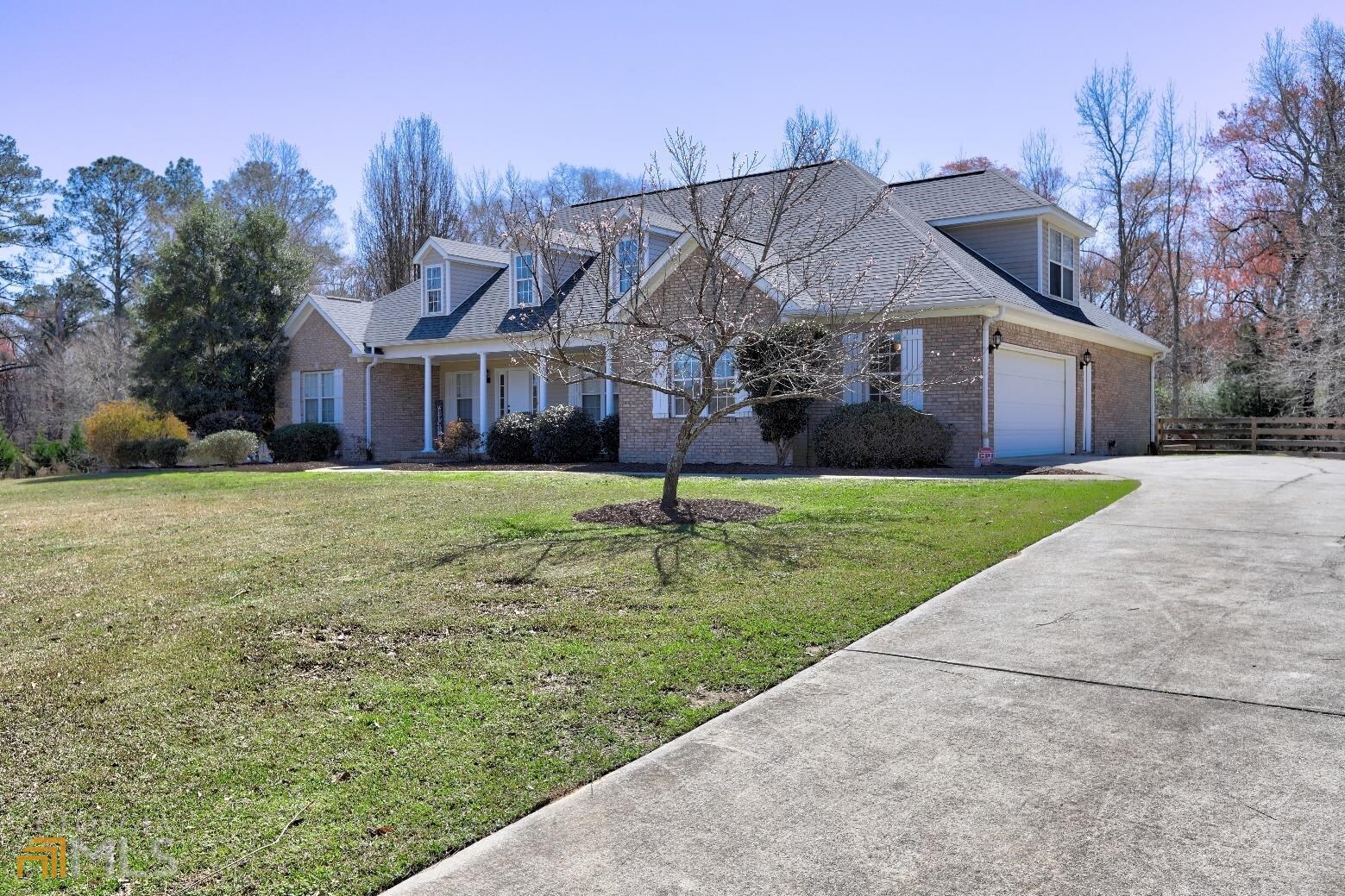 a view of a big house with a big yard and large trees