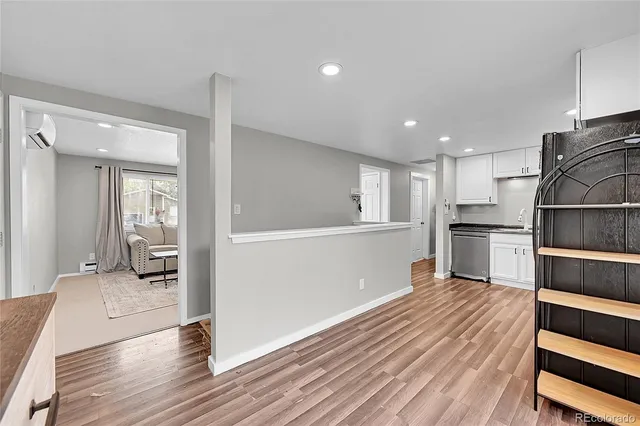 a kitchen with wooden floor and electronic appliances