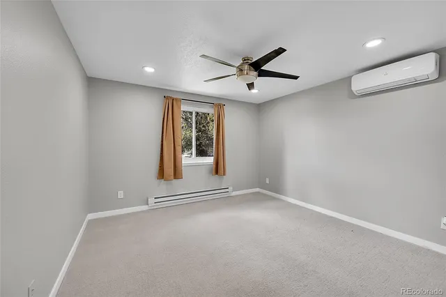 an empty room with window and ceiling fan