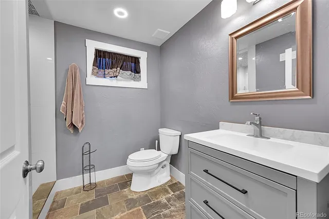 a bathroom with a toilet sink and mirror