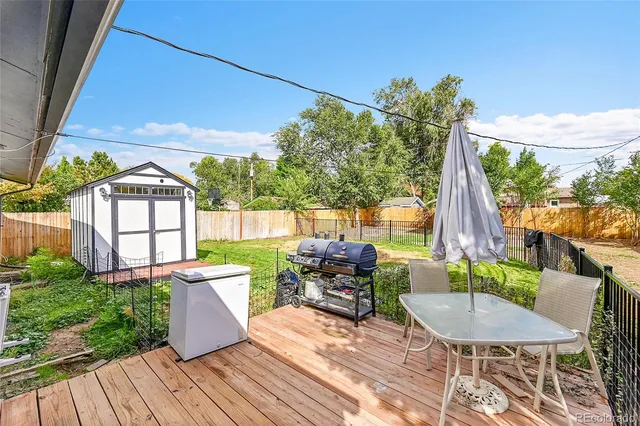 a view of a patio with table and chairs potted plants and wooden floor