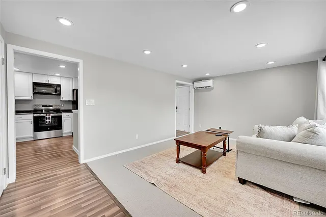 a living room with furniture and a wooden floor