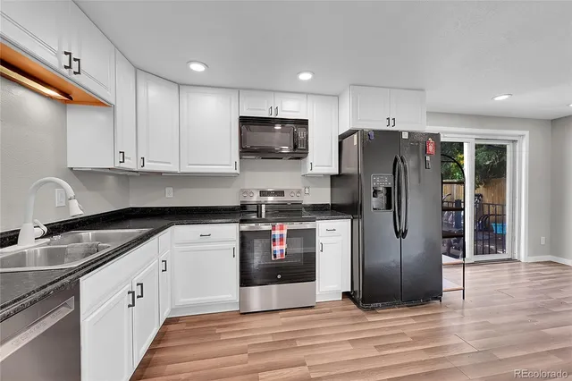 a kitchen with stainless steel appliances granite countertop a refrigerator sink and cabinets