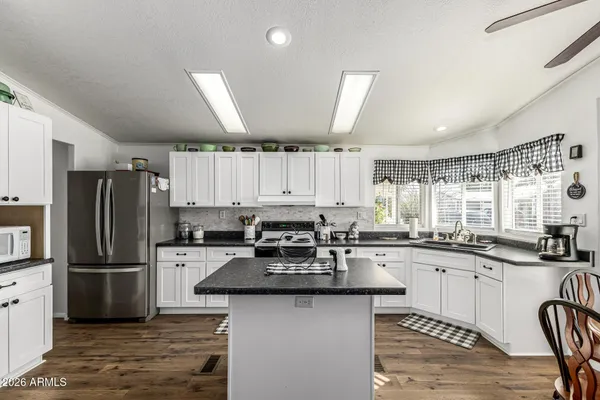 a kitchen with granite countertop a sink stove and refrigerator