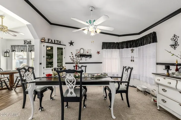 a view of a dining room with furniture and a chandelier fan