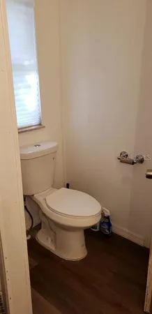 a white toilet sitting next to a window