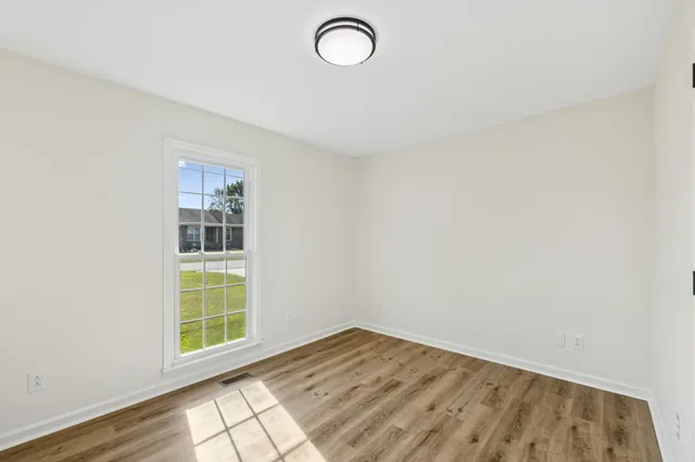a view of a room with wooden floor