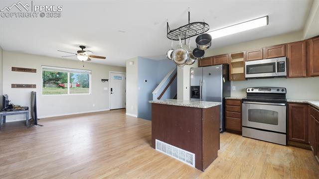 9715 Bar B Road Fountain, CO 80817 - Photo 8 of 34 The Island Kitchen includes wood cabinetry, granite countertops, & stainless steel appliances