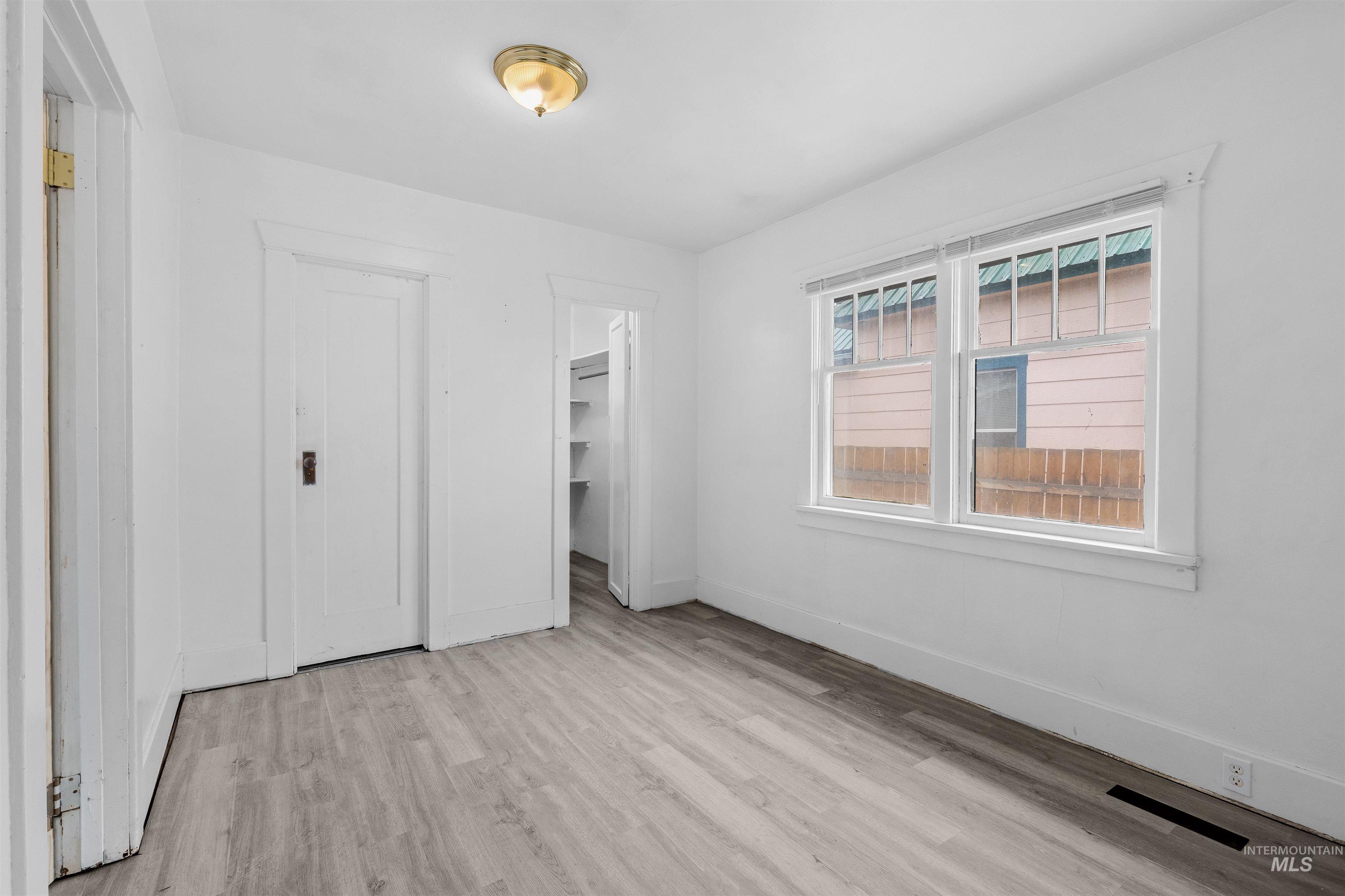 716 7th Street Clarkston, WA 99403 - Photo 17 of 38 Unfurnished bedroom featuring light wood-style flooring and a walk in closet