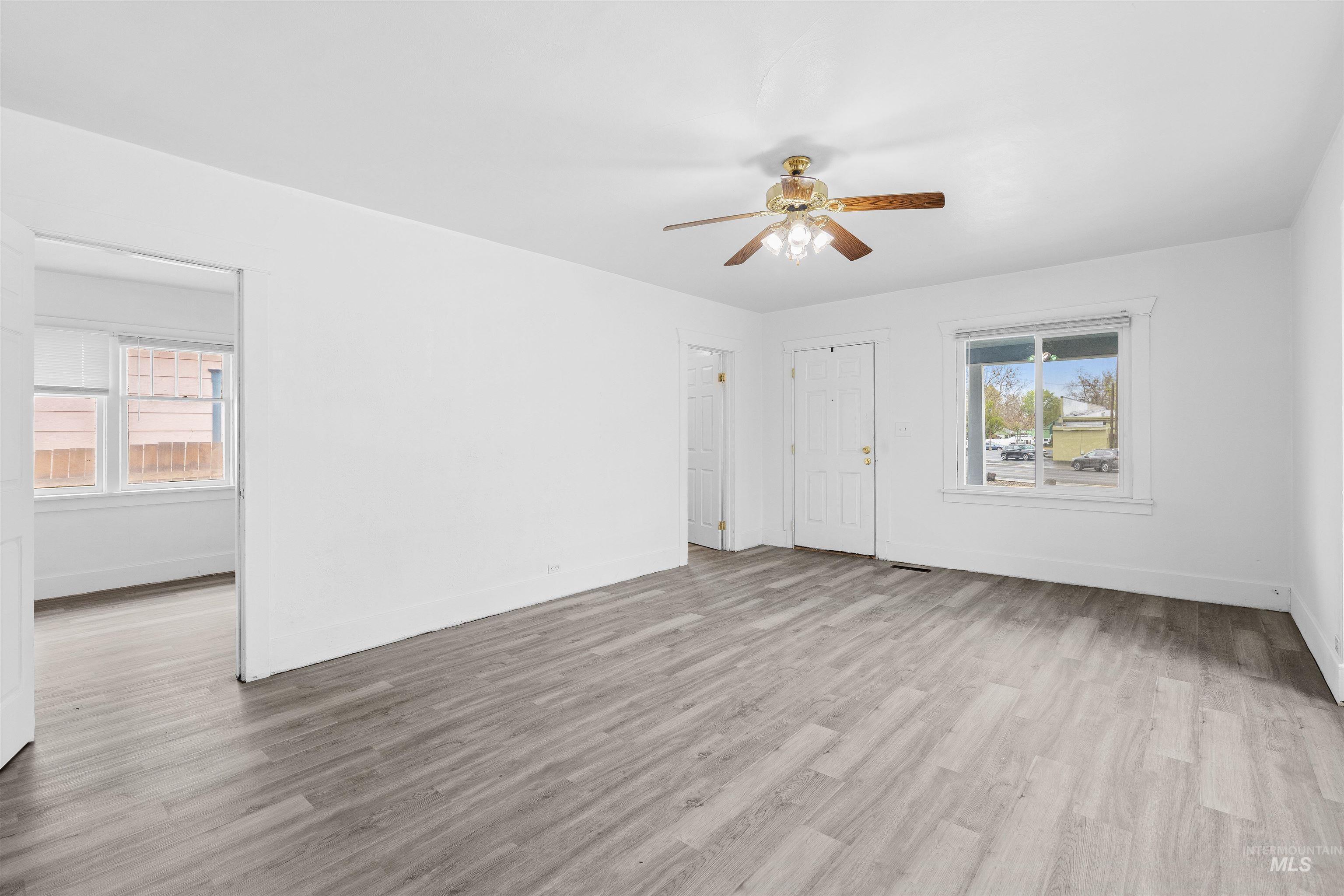716 7th Street Clarkston, WA 99403 - Photo 4 of 38 Unfurnished living room featuring ceiling fan, light wood-style flooring, and healthy amount of natural light