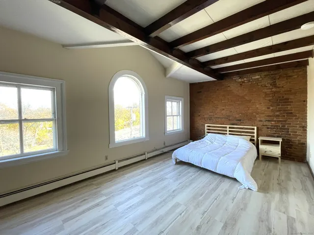 a spacious bedroom with a bed and a window