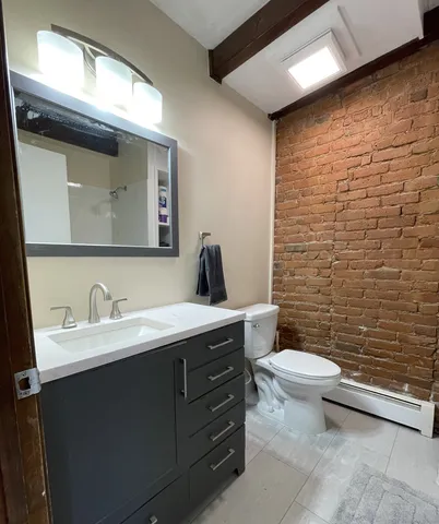 a bathroom with a toilet sink and mirror