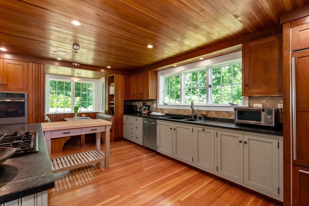 61 Dutton Road Sudbury, MA 01776 - Photo 12 of 42 a kitchen with stainless steel appliances granite countertop sink stove and wooden cabinets