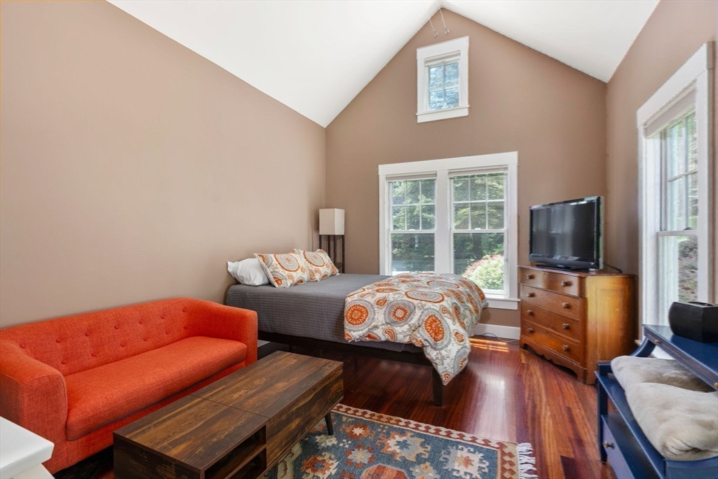 61 Dutton Road Sudbury, MA 01776 - Photo 37 of 42 a bedroom with furniture and a flat screen tv