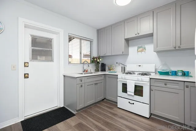 a kitchen with granite countertop white cabinets and white appliances