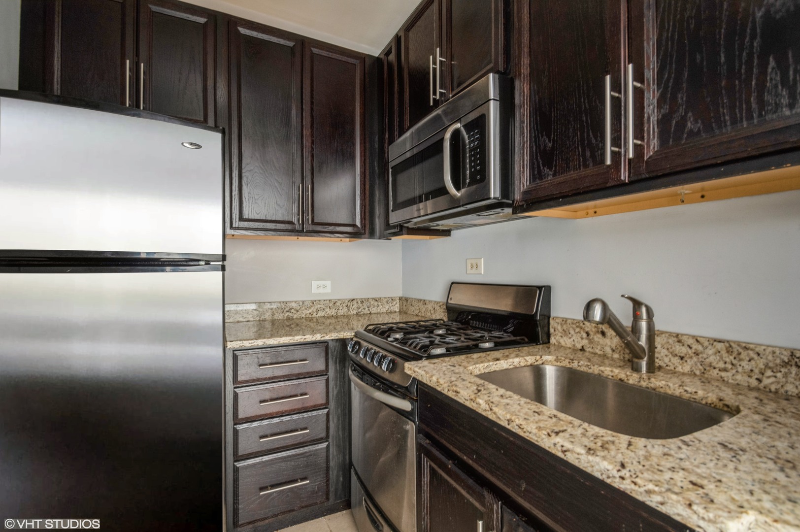 6101 North Sheridan Road, Unit 8B Chicago, IL 60660 - Photo 6 of 9 a kitchen with stainless steel appliances granite countertop a sink stove and refrigerator