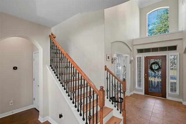 a view of staircase with railing and a chandelier