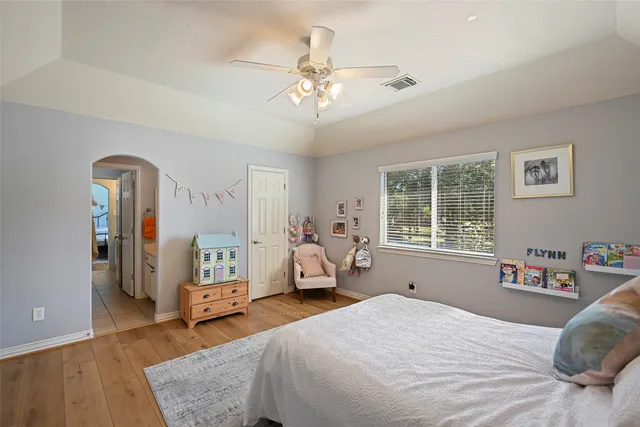 a bedroom with a bed and wooden floor