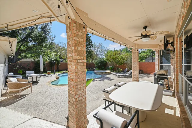 a view of a patio with a table and chairs and potted plants