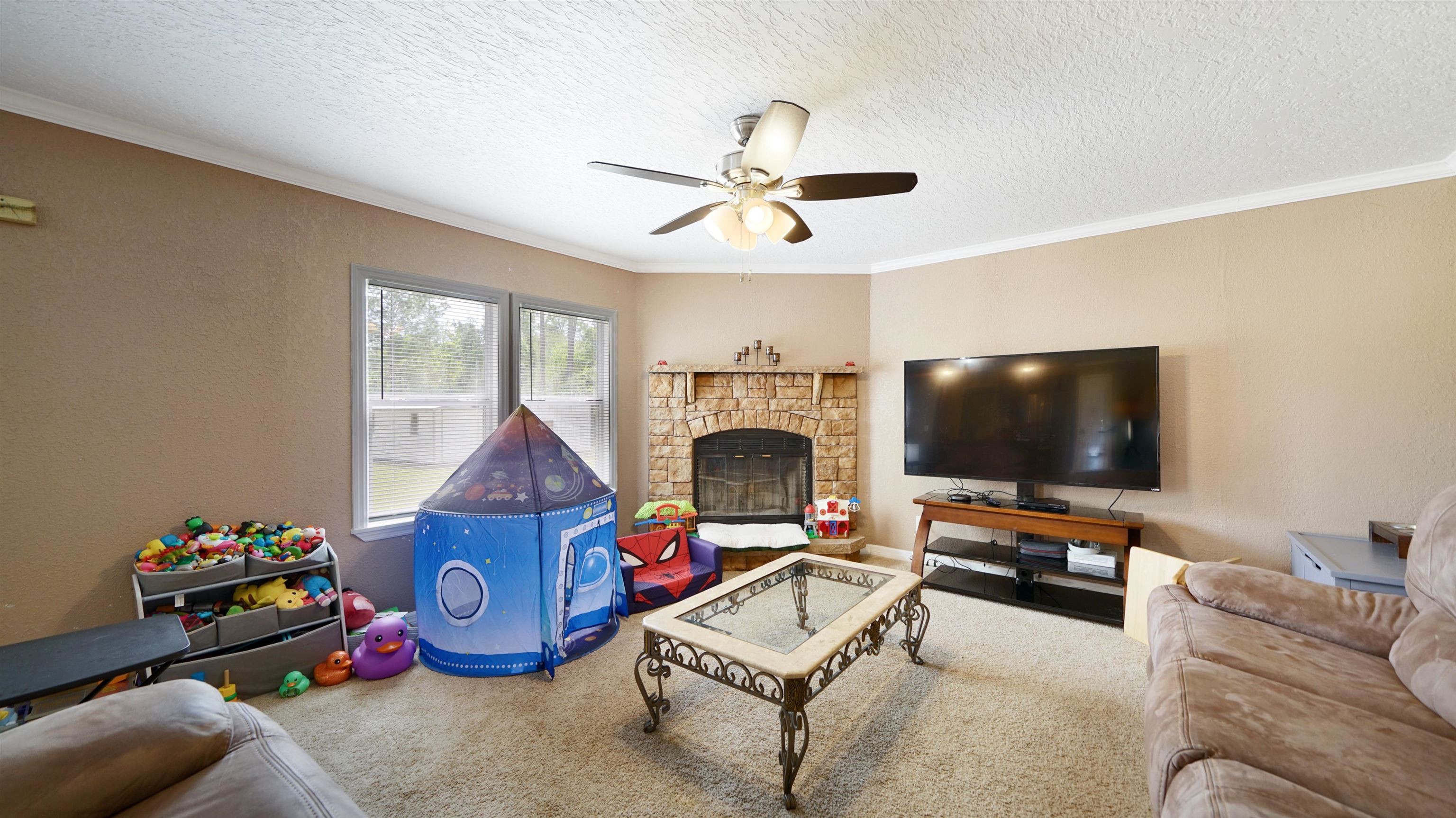 117 Jack Road Palatka, FL 32177 - Photo 11 of 34 a living room with furniture a flat screen tv and a fireplace