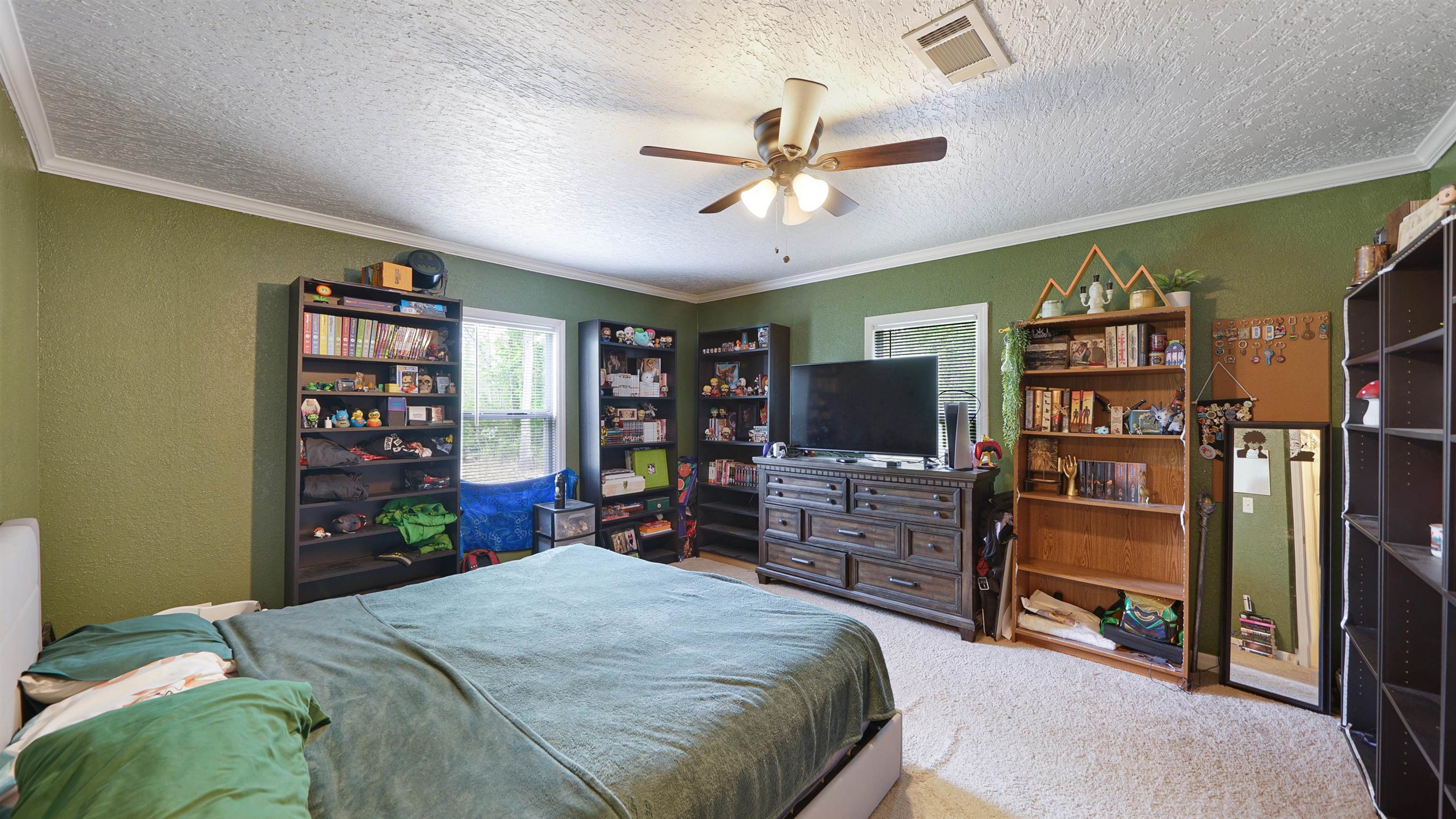 117 Jack Road Palatka, FL 32177 - Photo 17 of 34 a bedroom with a bed a dresser and a flat tv screen