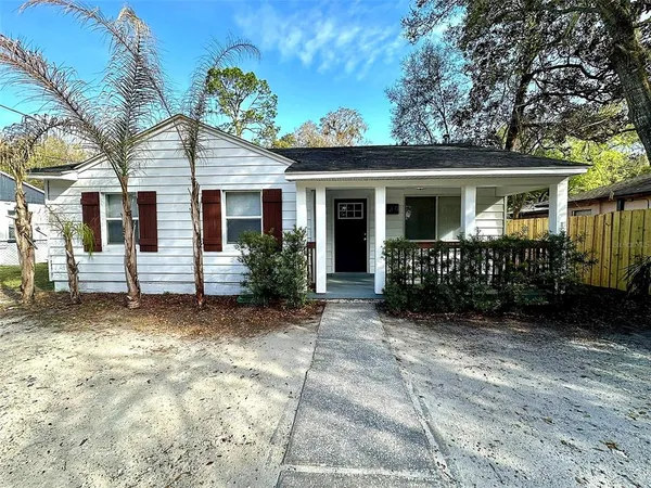 a view of a house with a yard and potted plants