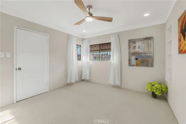 a view of an empty room with window and closet area